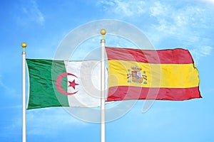 Algeria and Spain two flags on flagpoles and blue sky