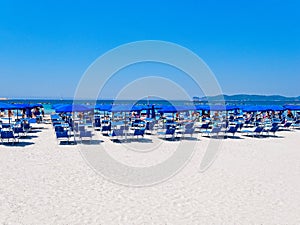 Alghero beach. Sea view, umbrellas and sun loungers. Sardinia, Italy.