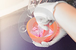 Alginate impression, orthodontist prepares a pink mixture to measure the patient`s mouth