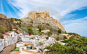 Alicante old town and Santa Barbara Castle on Benacantil hill. Narrow streets and white houses on hillside in ancient photo