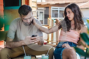 Alienation addiction. Couple sitting in cafe, typing on their phones