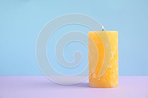 Alight wax candle on color background. Space for