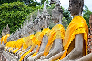 Aligned Buddha statues at Wat Yai Chaimongkol, Ayutthaya, Thailand.