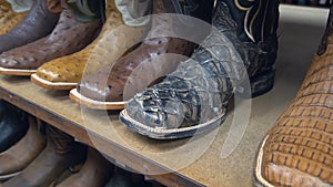 Aligned cowboys boots on a shelf in a store.