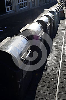 Aligned trashcans on the sidewalk