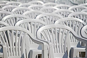 aligned white plastic chairs