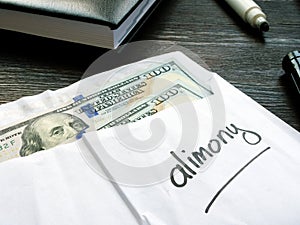 Alimony concept. Open envelope with cash on the desk. photo