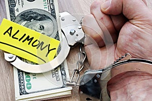 Alimony and hand in handcuffs. Legal separation.