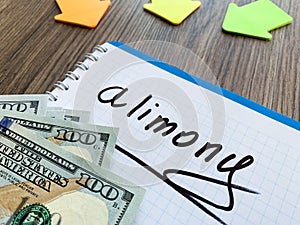 Alimony written on a notepad. Divorce and separation concept.