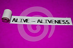 Alive - Aliveness text, Inspiration and positive vibes concept on purple torn paper photo
