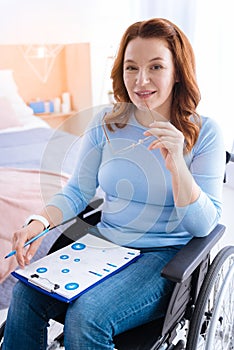 Alive handicapped woman smiling and holding glasses