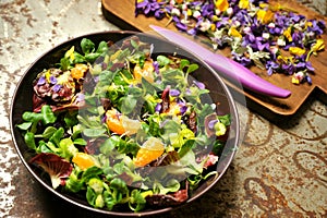 Alkaline, spring salad with flowers, fruit and valerian salad photo