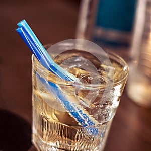 Alkohol drink with blue straw on the table