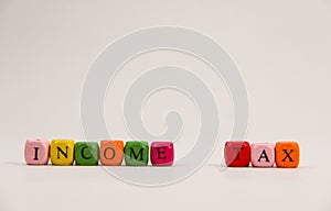 Income Tax alphabet at colourful cube block on white background