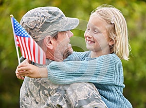 All families are different and unique. Shot of a father returning from the army hugging his daughter outside.
