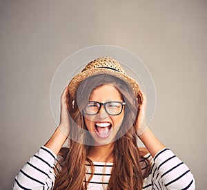 We all get a little crazy sometimes. Studio portrait of an attractive young woman screaming against a gray background.