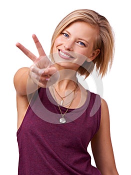 All Im saying is.... Studio shot of happy young woman giving the peace sign to the camera isolated on white.