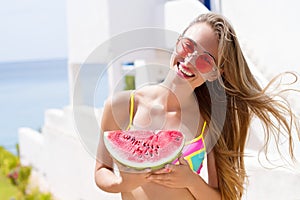 All Inclusive Cheap Summer Holidays. Young Happy Woman with Watermelon and pink sunglasses at beach Background. Summertime fun