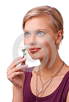 All natural perfume. Studio shot of an attractive young woman smelling a flower isolated on white.