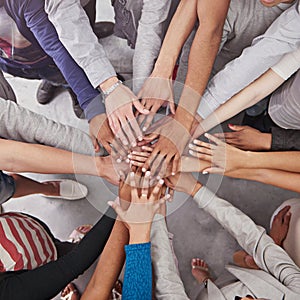 All for one and one for all. Cropped shot of a business team standing in a circle with their hands stacked.