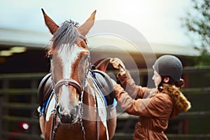 All prepped to ride her pony. a teenage girl preparing to ride her pony on a farm.