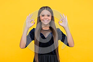 All right and alright. Child show OK signs yellow background. Happy girl smile with satisfaction. Agreed and acceptable photo