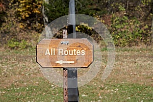 All Routes wooden signboard with arrow