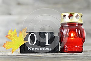All saints Day. Votive candle, wooden calendar and yellow autumn leaf
