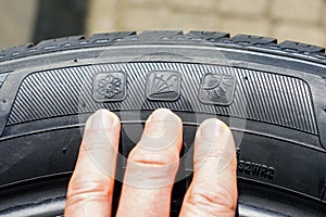 All season tire sidewall markings with images of snowflake, umbrella and sun