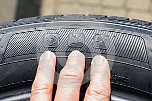 All season tire sidewall markings with images of snowflake, umbrella and sun photo