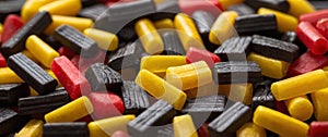 All sort licorice candies on bright yellow background.
