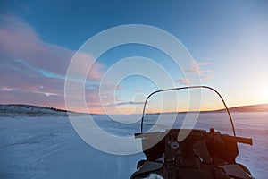 All-terrain vehicle at sunset in desert of snowy Siberia.