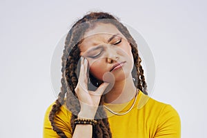 All this thinking is hurting my head. Studio shot of a young woman looking thoughtful against a gray background.