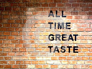 ALL TIME GREAT TASTE banner lettering on red, old orange brick wall background. Space for copy, text