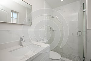 All white bathroom with glass door shower