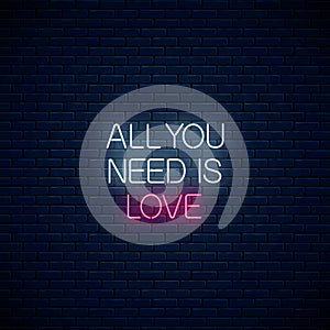 All you need is love - glowing neon inscription phrase on dark brick wall background. Motivation quote in neon style