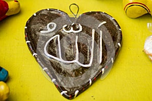 Allahu is written on a design made of clay and its back is blurred photo