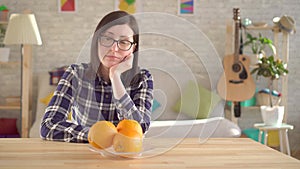 Allergic to oranges.The young woman sniffs and looks at the oranges