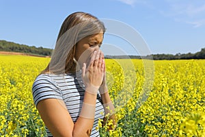 Allergic woman coughing in a yellow field