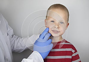 An allergist or dermatologist examines red spots on a childâ€™s face. The boy suffers from a rash, hives and itching. Food Allergy