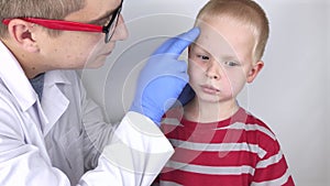 An allergist or dermatologist examines red spots on a childâ€™s face. The boy suffers from a rash, hives and itching. Food Allergy