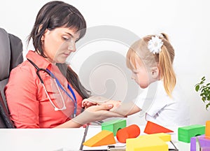 An allergist doctor examines the hand of a little girl for allergies. The concept of allergy to insect bites, dust and medications photo