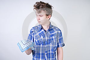 Allergy Boy Child with runny nose holding a handkerchief. Teenager is having bad health and standing on white studio background al