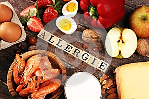 Allergy food concept. Allergy food as almonds, milk, cheese, strawberry, eggs, peanuts and .crustaceans or shrimps with wooden