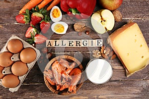 Allergy food concept. Allergy food as almonds, milk, cheese, strawberry, eggs, peanuts and .crustaceans or shrimps with wooden