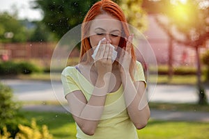 Allergy make trouble in nose! Young redhair woman sneezing. Pollen Allergy symptoms