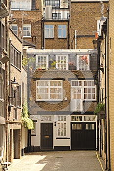 Alley with benches surrounded by buildings with windows in London