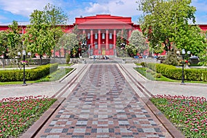 Alley leads to an unusual bright red building with columns