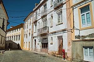 Alley of old colorful terraced houses with worn plaster wall