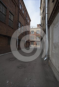 The alley between the old factory buildings inside the factory closed block in an industrial area of old European cities.